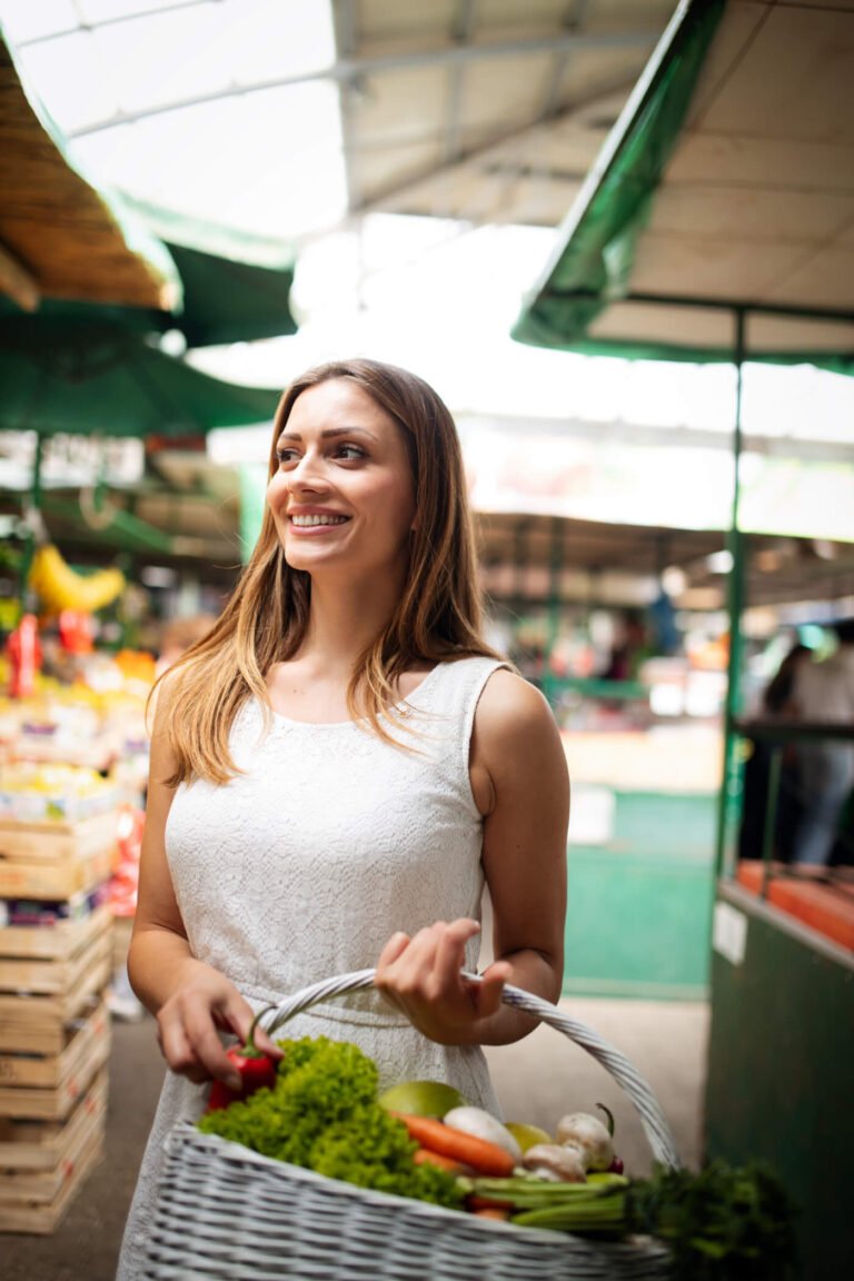 a woman holding a basket of vegetables