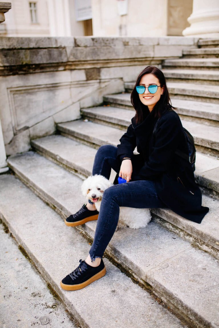a person sitting on stairs with a dog