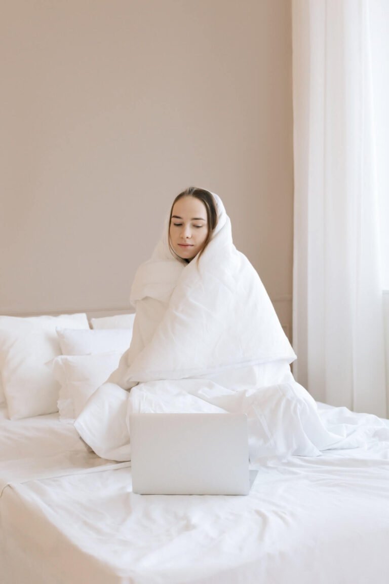 a person in a white robe sitting on a bed