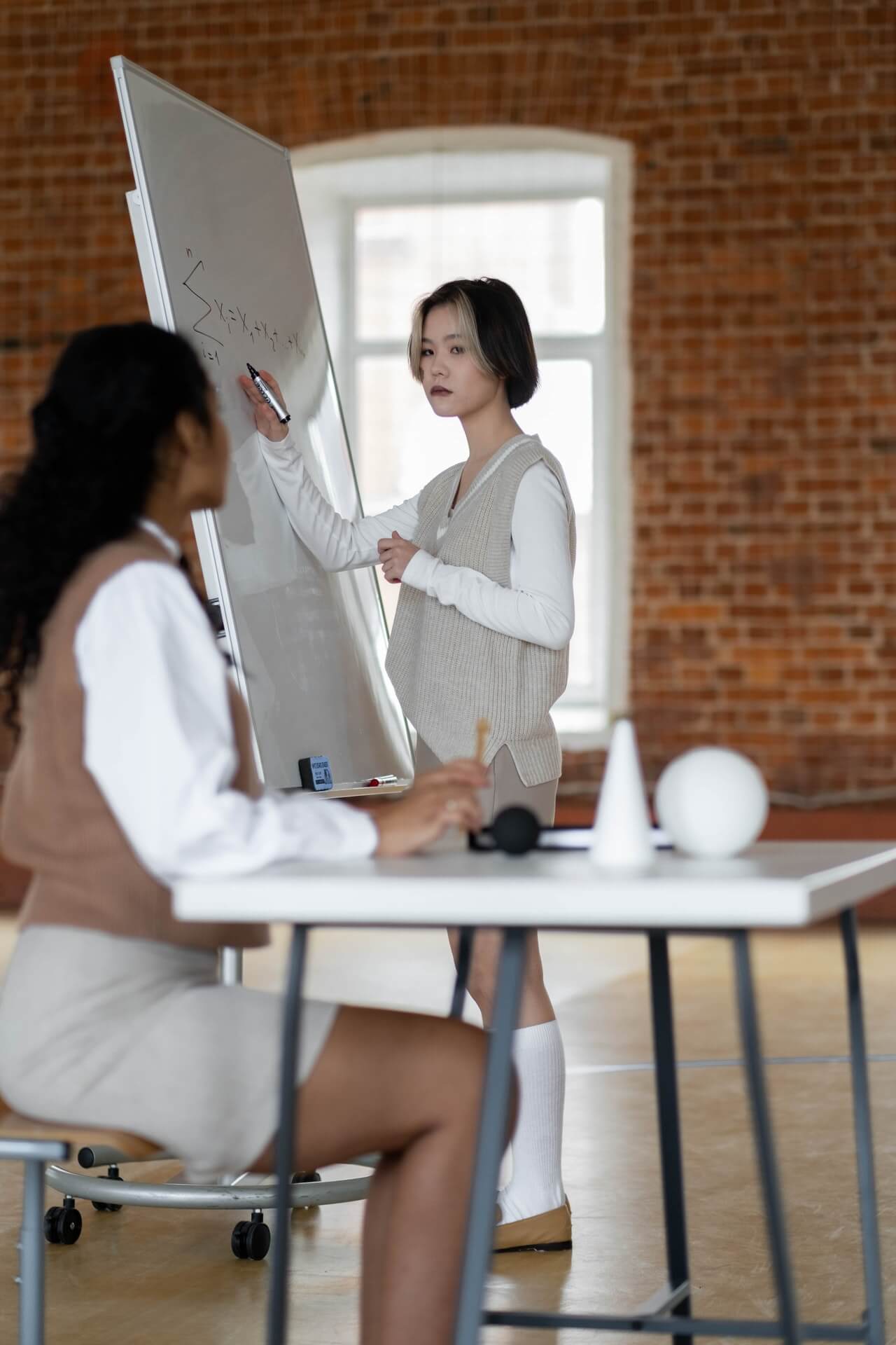 a person and a young girl looking at a white board