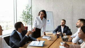 Businesswoman On Business Meeting Talking With Colleagues Standing In Office