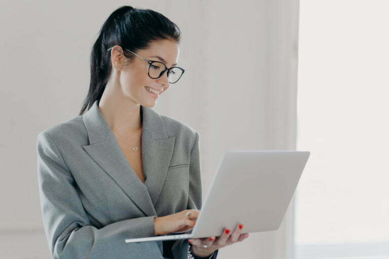 Self confident cheerful woman economist analyzes report about company income on laptop computer