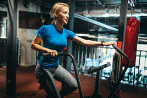 Fit woman working out on the exercise bike at the gym